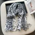 Detailed view of the stylish grey leopard print scarf, showcasing lightweight sheer fabric texture. - 160x50cm / Grey Black Leopard