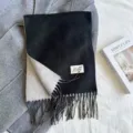 Detailed shot of the black and white faux cashmere scarf with elegant tassels and woven label. - Black and Gray