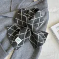 Detailed shot of winter cross knitted scarf in dark grey with elegant diamond pattern warm. - Gray