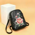 Exquisite floral embroidery detail on black leather shoulder bag surface, stylish and elegant. - Flowers on the Path