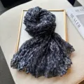 Detailed view of a stylish black and grey leopard print pleated scarf, elegant fashion accessory. - Black and Gray