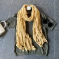 Detailed view of a yellow striped crinkle scarf paired with an olive green knit top, chic style. - Yellow