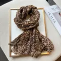 Detailed view of fashionable leopard print crinkled scarf, soft fabric with chic texture. - Khaki Yellow