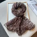 Detailed view of the stylish leopard print crinkle scarf, showing soft textured fabric texture. - Coffee