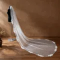 Detailed shot of long wedding veil featuring delicate lace edge and hand-sewn beaded design. - Off-White (3m Cathedral)