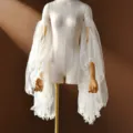 Close-up detail of sheer white tulle ruffled detachable bridal sleeves, delicate mesh design. - Off White