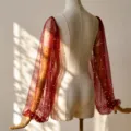 Detail showcase of sheer burgundy mesh sleeves featuring delicate white faux pearls design. - One Size / Red