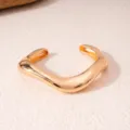 Detailansicht eines stylischen goldenen geometrischen offenen Armbands, ideal für Mode. - Gold Stil 1