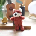 Primo piano dettagliato di un simpatico ciondolo in peluche di volpe rossa e morbida. - Volpe