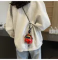 Nahaufnahme des stilvollen floralen Mini-Rucksack-Anhängers mit Stofftextur und Trageriemen. - Rot
