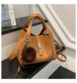 Fashionable women's bucket bag with litchi pattern, top handles, and chic metal lock. - With Pendant / Tan