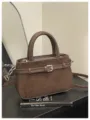 Brown suede texture handbag detail, elegant buckle strap decoration and shoulder strap design. - Coffee