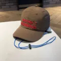Detail shot of brown kids quick-drying baseball cap with blue wind rope and red embroidery. - 4-10 Years / Coffee