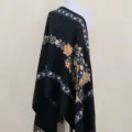 Detailansicht des schwarzen bestickten Winterschals mit lebendigen Blumenmustern und Quasten. - Schwarz