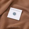 Detailweergave van de ronde platte gekleurde hijab magneet, ideaal om sjaals stevig vast te zetten. - 1 Stuk/Verpakking / Blauwgrijs