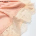 Katoenen linnen sjaaldetail met elegante kantrand en delicate parelversieringen. - Lichtroze