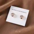 Detail shot of round rose gold magnetic hijab pins on white display card with fabric. - COL.23 Rose Gold