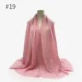 Close-up detail of a solid pink crinkled hijab headscarf and shawl showing soft texture. - Style 19