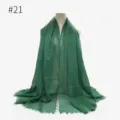 Dark green crinkled texture scarf detail showcasing the soft fabric grain and elegant fringe. - Style 21