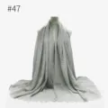 Vista di dettaglio della sciarpa stropicciata in cotone TR grigio con frange e trama. - Stile 47