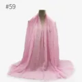 Dettaglio sciarpa stropicciata rosa, mostra consistenza morbida, bordi con frange e drappeggio. - Stile 59