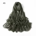 Close-up detail of the dark green shimmering viscose scarf showing metallic threads and fringe. - Green