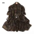 Detail view of the elegant brown and green plaid chiffon scarf hanging on display. - Style #10