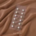 Nahaufnahme von zwölf eleganten weißen Perlen Magnet Schalschnallen und Manschettenknöpfen. - 12 Stück/Packung / Weiß