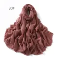 Close-up of a solid color crinkled linen gauze scarf with frayed tassel edges, soft drape. - Dark Pink