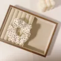 Primo piano dettagliato del morbido scrunchie francese a pois posizionato su vassoio. - Anello per Capelli a Pois