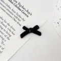 Black bow knot jewelry accessory detail shot, perfect for DIY crafts and charm bracelets. - Black