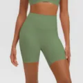 Vista dettagliata in primo piano di pantaloncini da yoga fitness verdi a vita alta elasticizzati. - Verde Cedro