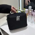Zwarte geweven cosmetische tas met grote capaciteit, handvat en soepele ritssluiting. - Zwart