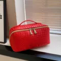 Rode geweven cosmetische tas, stijlvolle toilettas met handvat en gouden dubbele ritssluiting. - Rood