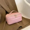 Pink quilted PU leather cosmetic bag with gold zipper and handle for women daily travel storage. - Pink