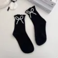 Black mid-tube socks featuring elegant pearl bow design and delicate lace trim for cute daily wear. - One Size / Black Bowknot