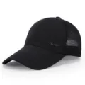 Detailed view of a black nylon baseball cap with breathable mesh and metal logo accent. - Adjustable / Black
