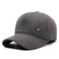 Close-up detail of the dark grey woolen baseball cap showing tweed texture and metal badge. - Adjustable / Gray