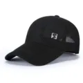 Close-up view of the black breathable mesh baseball cap, showing the textured fabric and patch detail. - Adjustable / Black