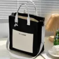Closeup of black canvas tote bag front pocket and handle strap, showing durable fabric details. - Black and White Colorblock [Upgraded] with Lining