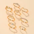 Conjunto de anillos de moda dorados con disenos de amor ancla y cristales para mujeres. - Serie Letra Corazón Símbolo Infinito (8 Piezas)
