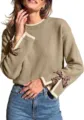 Close-up of women's knit sweater featuring contrast ribbed cuffs and stylish leopard bows. - Oatmeal