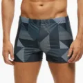 Nahaufnahme Detail von geometrisch gemusterten Boxer Badehosen mit modernem Muster. - S / Grau
