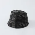 Vue détaillée du bob camouflage usé montrant une texture de tissu rétro et un délavage sombre. - 50-52cm / Chapeau seau