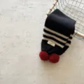 Dettaglio sciarpa in maglia per bambini a righe bianco nero pon pon rossi collo invernale caldo - Nero
