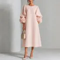 Vista detallada del elegante vestido midi rosa con puños florales 3D y delicados botones. - XS / Vestidos / Rosa