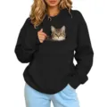 Detailopname van de grappige kattenprintzak en knusse fleecestof op de zwarte hoodie. - S / Tops / Zwart