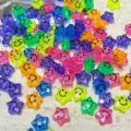 Primo piano di perline stella in acrilico colorato con viso sorridente, accessori. - Facce Sorridenti Multicolore