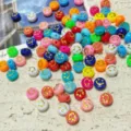 Primer plano detallado de cuentas planas de acrilico de colores con sonrisa para joyeria DIY - Caras Sonrientes Multicolores