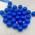 Dettaglio in primo piano di perline tonde in acrilico blu solido per gioielli fatti a mano. - Blu